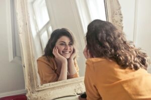 woman looking at the mirror with smiling