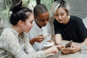 three people looking at the iphone curiously
