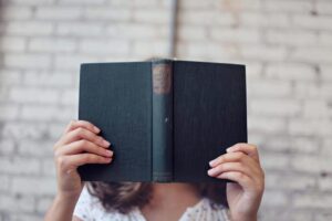 woman covering her face with a book